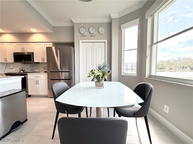 tiled dining area featuring crown molding