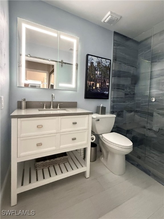 bathroom with walk in shower, vanity, and toilet