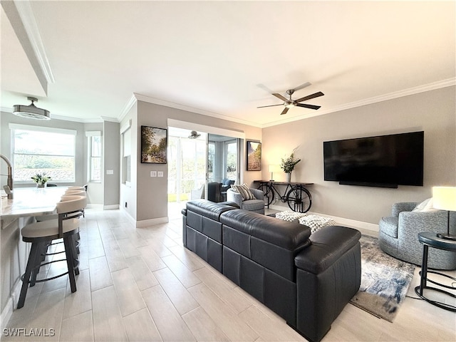 living room featuring ceiling fan, crown molding, and plenty of natural light