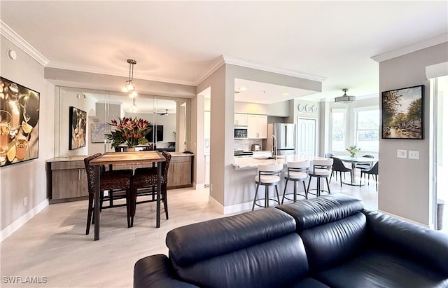 living room with light wood-type flooring, sink, and crown molding