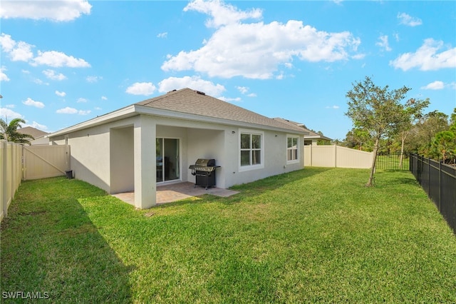 rear view of house with a patio and a lawn