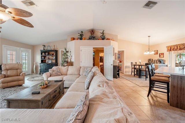 living room with light tile patterned floors, ceiling fan with notable chandelier, vaulted ceiling, and plenty of natural light