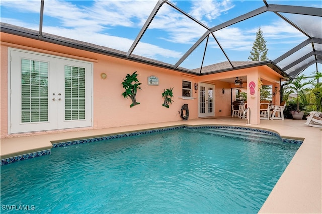 view of pool featuring a lanai, ceiling fan, a patio area, and french doors