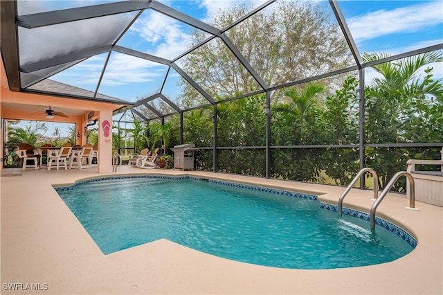 view of pool featuring a patio area, ceiling fan, and glass enclosure