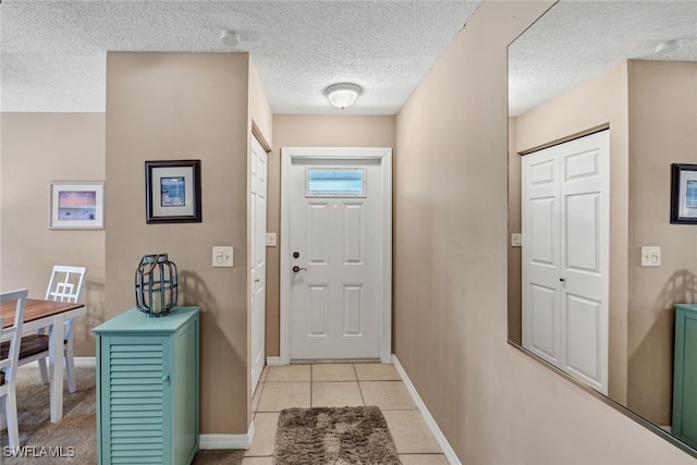 entryway featuring a textured ceiling and light tile patterned flooring