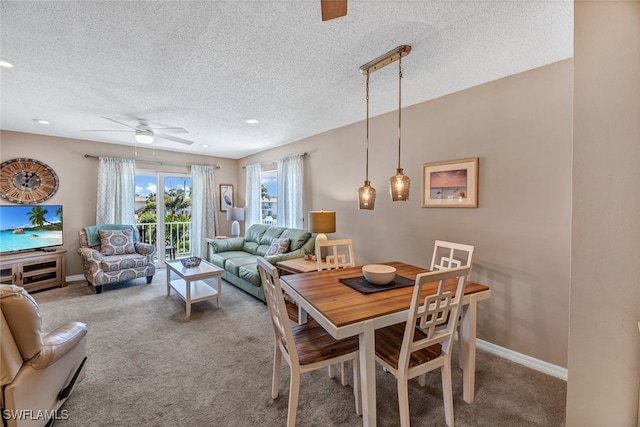 carpeted dining room featuring a textured ceiling and ceiling fan