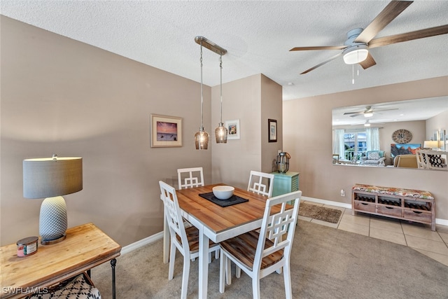 dining space featuring light colored carpet, a textured ceiling, and ceiling fan