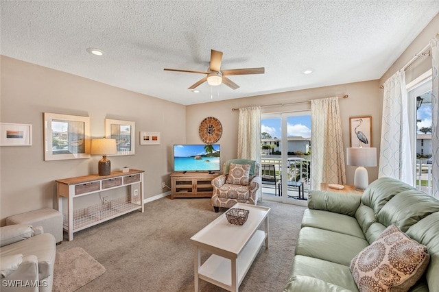 living room with a textured ceiling, light colored carpet, and ceiling fan