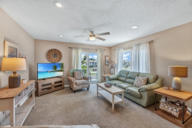 living room with a textured ceiling, light carpet, and ceiling fan