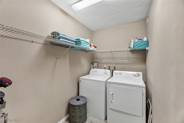 washroom with a textured ceiling and washer and clothes dryer