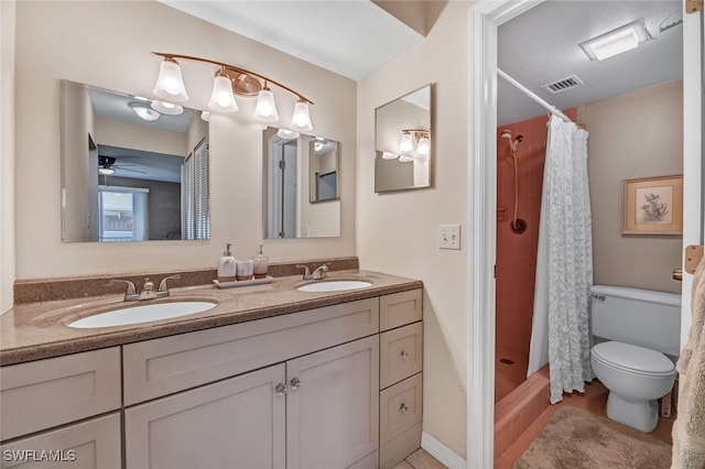 bathroom featuring curtained shower, vanity, ceiling fan, and toilet