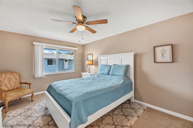 bedroom featuring a textured ceiling, light colored carpet, and ceiling fan