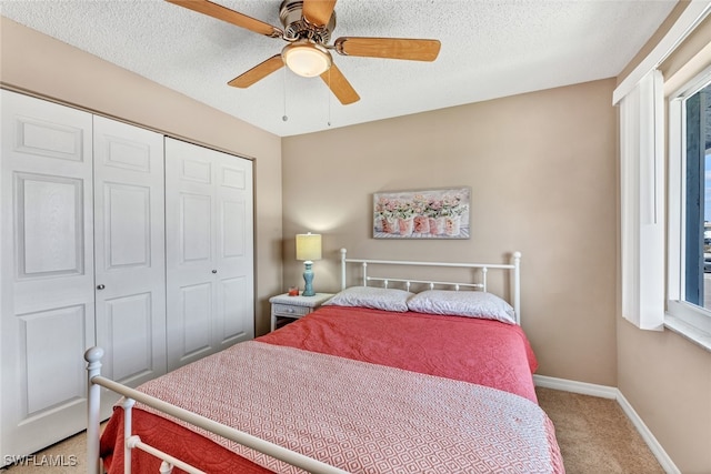 bedroom featuring a closet, a textured ceiling, carpet flooring, and ceiling fan