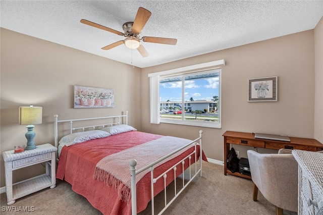 bedroom with ceiling fan, a textured ceiling, and carpet flooring