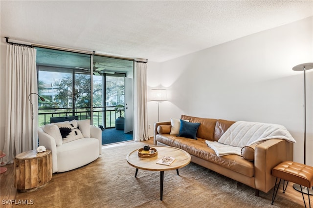 carpeted living room featuring expansive windows and a textured ceiling