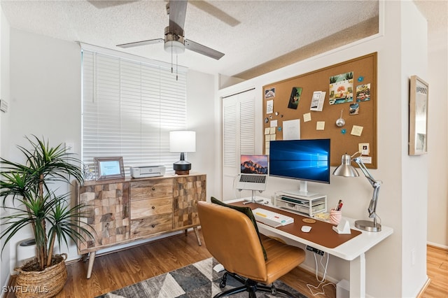 home office featuring hardwood / wood-style flooring, ceiling fan, and a textured ceiling