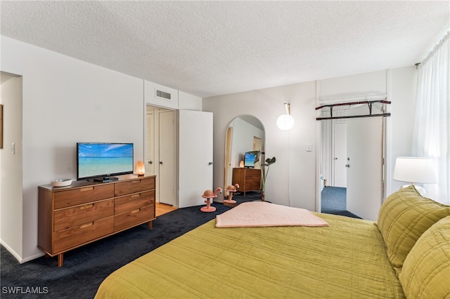 bedroom with a textured ceiling and carpet