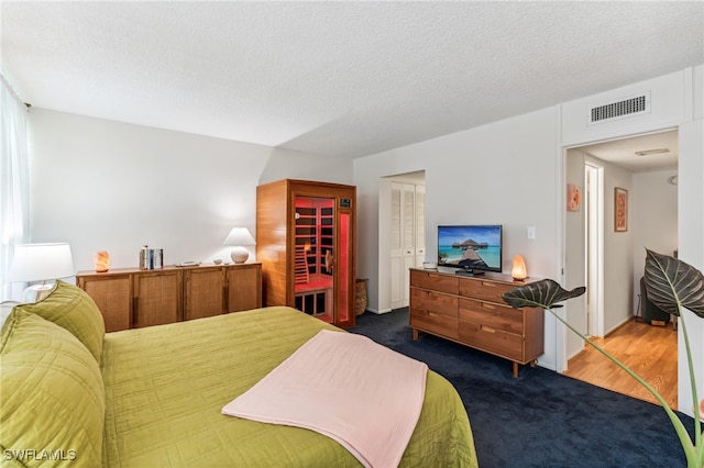 bedroom with dark hardwood / wood-style flooring and a textured ceiling