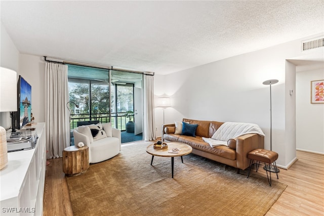 living room with wood-type flooring and a textured ceiling