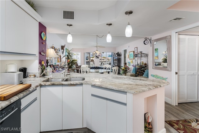 kitchen with sink, dishwasher, kitchen peninsula, white cabinets, and hardwood / wood-style flooring