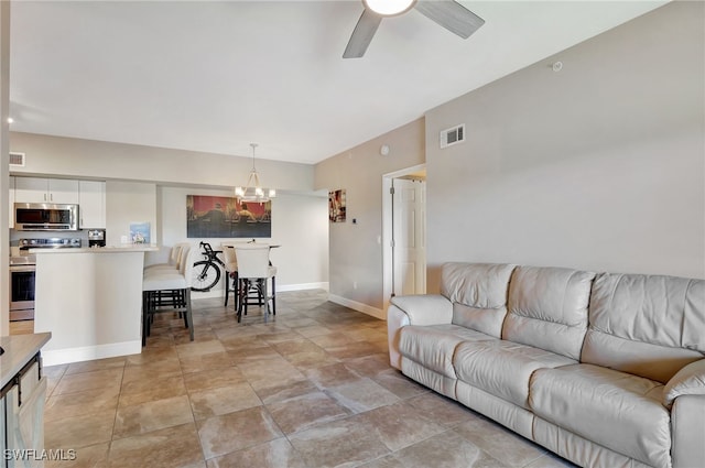 living room featuring ceiling fan with notable chandelier, visible vents, and baseboards