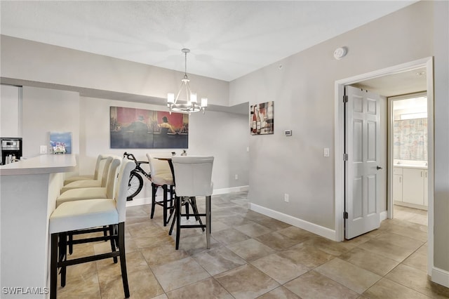 dining room featuring a notable chandelier and baseboards