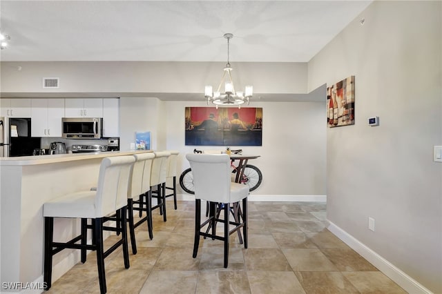 dining area featuring a chandelier, visible vents, and baseboards