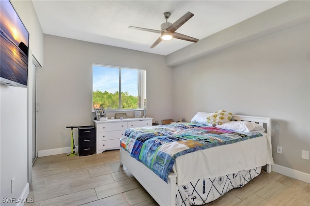 bedroom featuring wood tiled floor, a ceiling fan, and baseboards