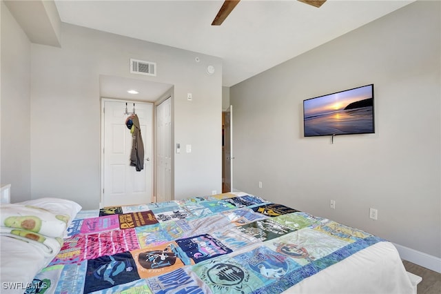 bedroom with ceiling fan, wood finished floors, visible vents, and baseboards