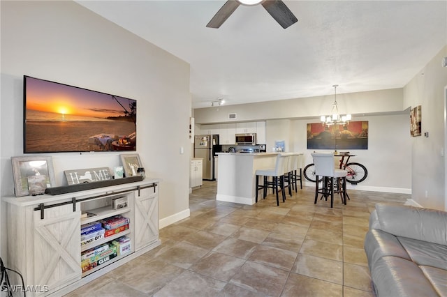 living area featuring light tile patterned floors, visible vents, baseboards, and ceiling fan with notable chandelier