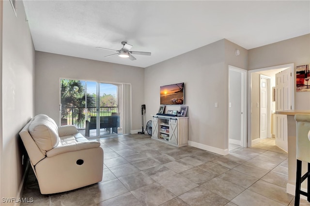 sitting room featuring light tile patterned floors, a ceiling fan, and baseboards