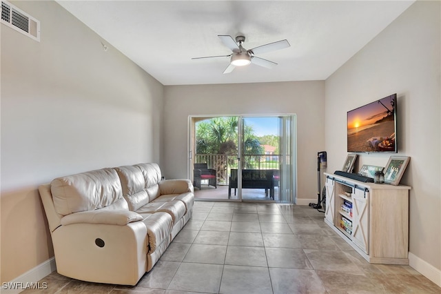 living area featuring light tile patterned floors, baseboards, visible vents, and a ceiling fan