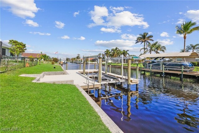 view of dock with a lawn and a water view