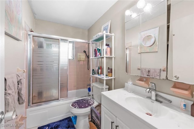 full bathroom with shower / bath combination with glass door, vanity, and toilet