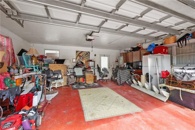 garage featuring white refrigerator and a garage door opener