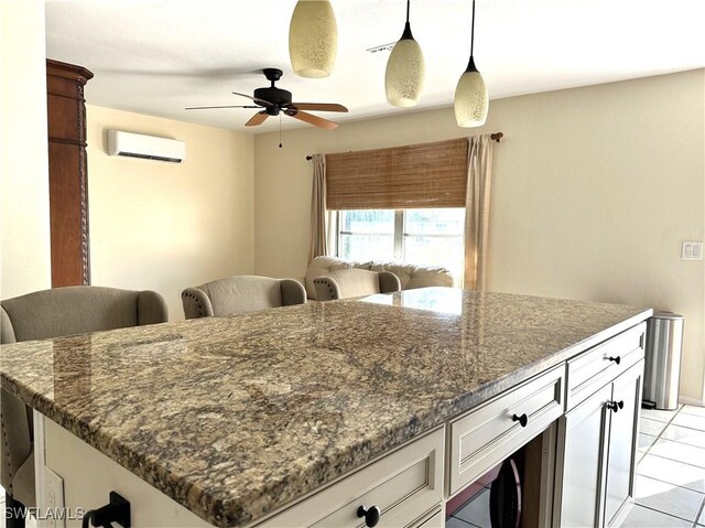 kitchen with white cabinets, an AC wall unit, ceiling fan, dark stone countertops, and light tile patterned flooring