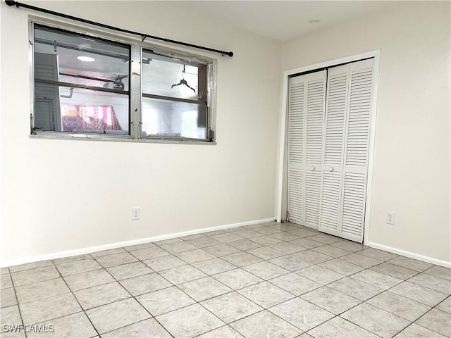 unfurnished bedroom featuring light tile patterned floors and a closet