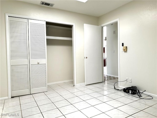 unfurnished bedroom featuring light tile patterned floors and a closet