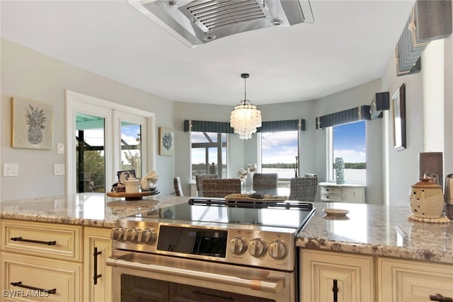 kitchen with plenty of natural light, light stone countertops, and high end stove