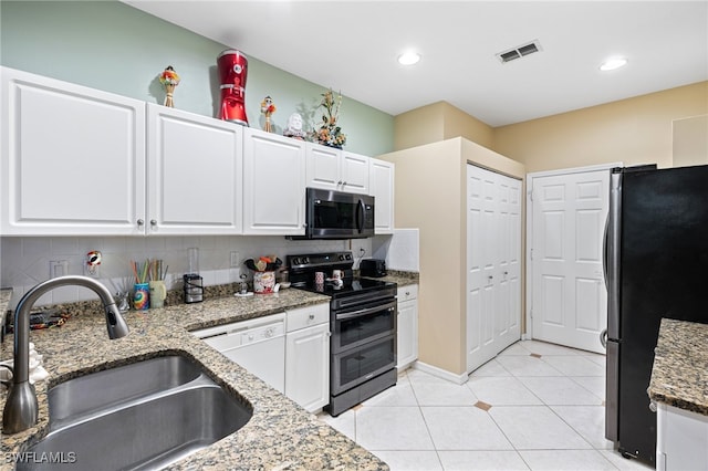 kitchen featuring light stone counters, stainless steel appliances, white cabinetry, backsplash, and sink