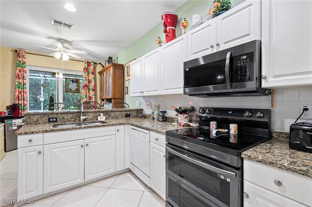 kitchen with white cabinetry, appliances with stainless steel finishes, sink, and dark stone countertops