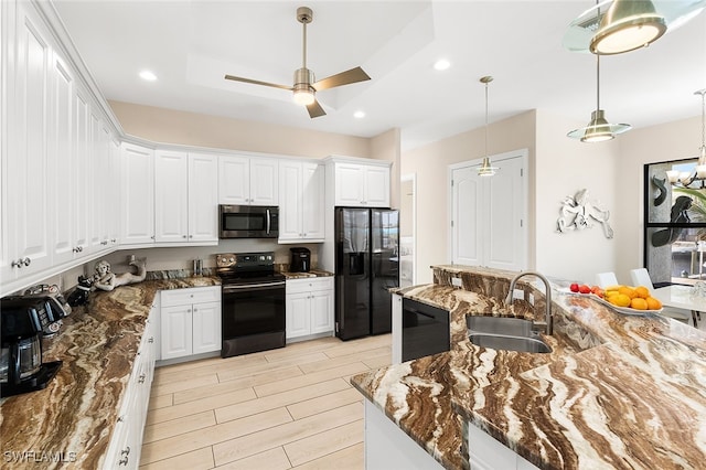 kitchen featuring black appliances, white cabinetry, sink, light hardwood / wood-style floors, and dark stone countertops