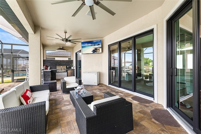 view of patio / terrace with an outdoor kitchen, ceiling fan, glass enclosure, and an outdoor living space