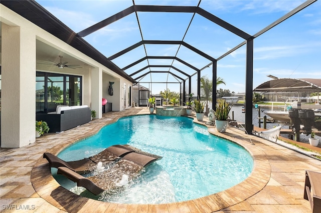 view of pool with a patio, glass enclosure, ceiling fan, and an in ground hot tub