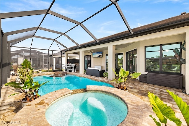 view of pool with ceiling fan, glass enclosure, an in ground hot tub, and a patio area