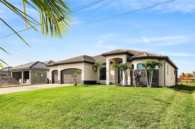 mediterranean / spanish house featuring a garage and a front yard