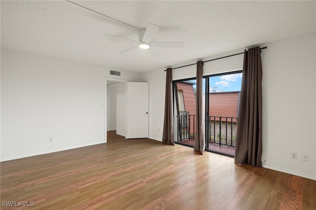 unfurnished room featuring visible vents, a ceiling fan, a textured ceiling, wood finished floors, and baseboards