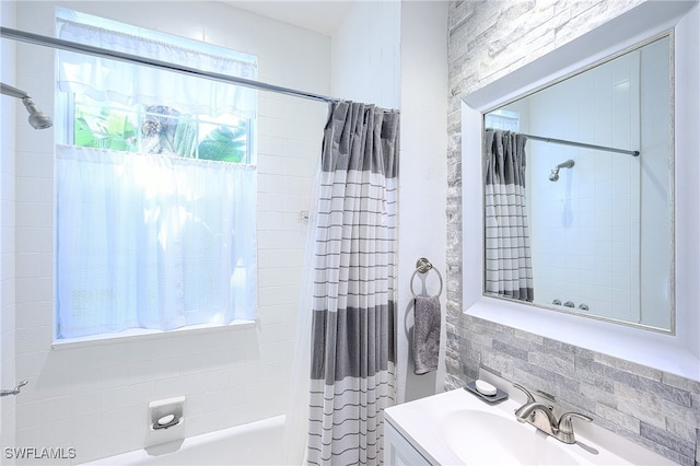 bathroom with shower / tub combo with curtain, vanity, and a healthy amount of sunlight