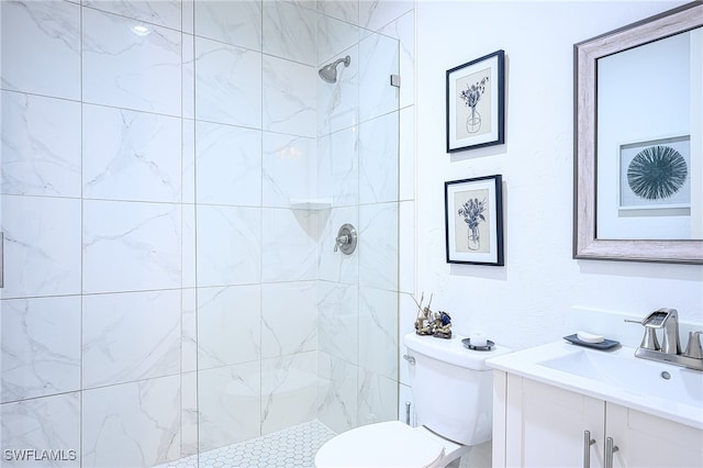 bathroom with tiled shower, vanity, and toilet