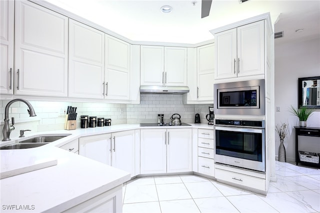 kitchen featuring backsplash, white cabinetry, sink, and stainless steel appliances